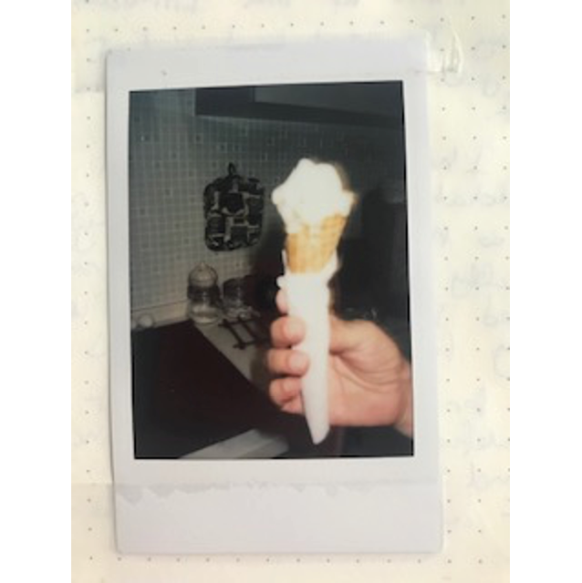 A hand holding an ice cream cone