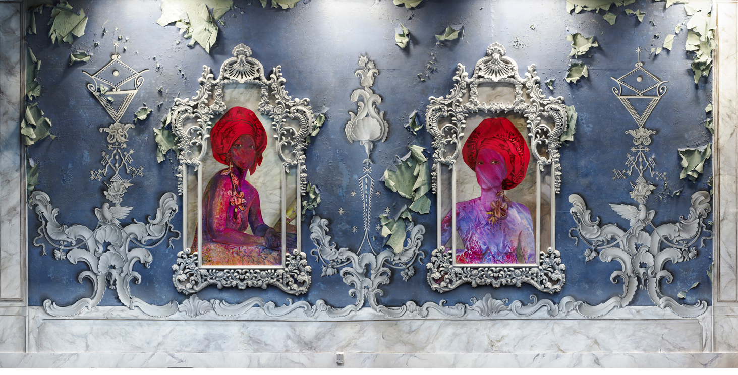 This installation by Firelei Báez includes an ornately decorated midnight blue wall with equisite white molding. The wall appears to be in a state of disrepair as the wallpaper is beginning to peel off the wall, exposing a sea-foam green paper edge. Mounted on the wall are two framed portraits of Amethyste and Athenaire, the daughters of Queen Marie-Louise Coidavid. The daughters are rendered with prismatic puple and magenta skin. Each one wears a brilliant red tignon. Only their eyes are visible amidst the swirling layers of paint.