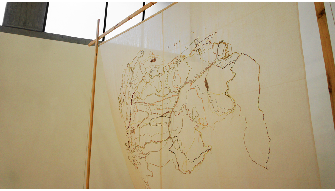 A map of the border of Colombia and Venezuela. The map is embroidered with red thread on a white loom.