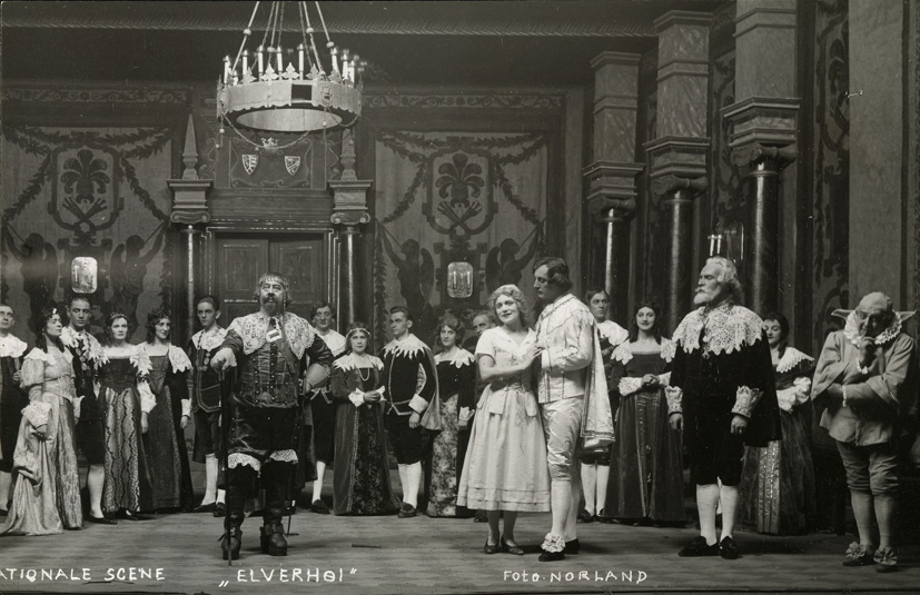 An act from the comedy Elverhøj at Den Nationale Scene. Oslo (1926), photograph by Selmer Malvin Norland. A group of people in a balroom, crowded around a man and a couple.