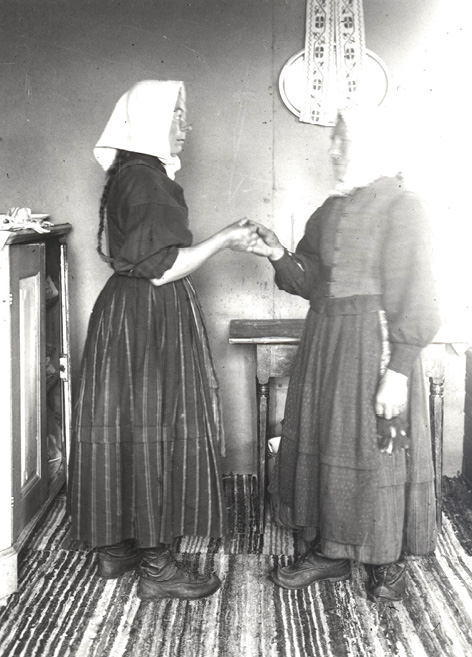 Two women in Tjöck show how to take hand in hand the minuet (1928). Photograph by Yngvar Heikel.