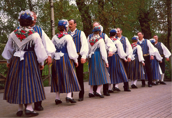 Twelve Munsala folk dancers in traditional costumes dance their minuet in Stockholm (1987). Photograph by Stina Hahnsson.