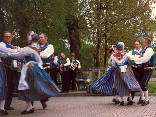 Twelve Munsala folk dancers in traditional costumes dance their polska in Stockholm (1987). Photograph by Stina Hahnsson.