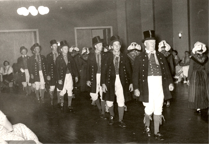 Sixteen Danish folk dancers dance a minuet from Randers. Photograph.