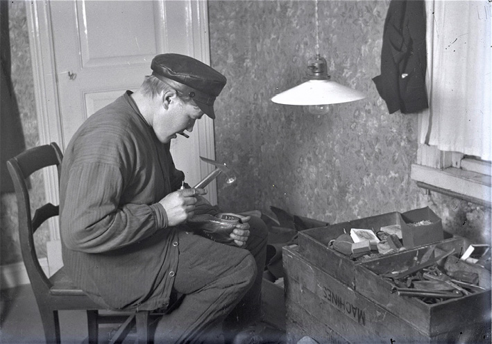 A cobbler fitting a shoe with a new heel in Ostrobothnia (1921). Photograph by Erik Hägglund.