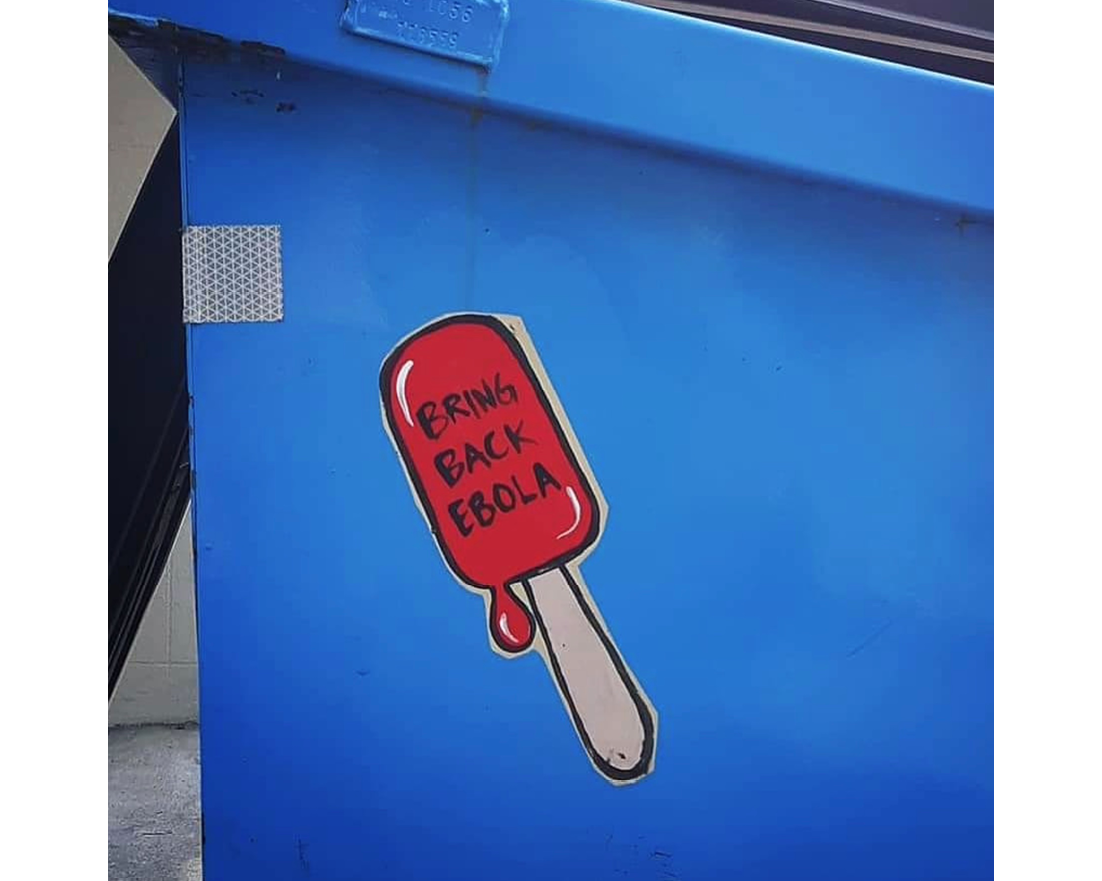 A wheat paste image depicting a red popsicle on a bright blue dumpster. Text reads 'Bring Back Ebola.'