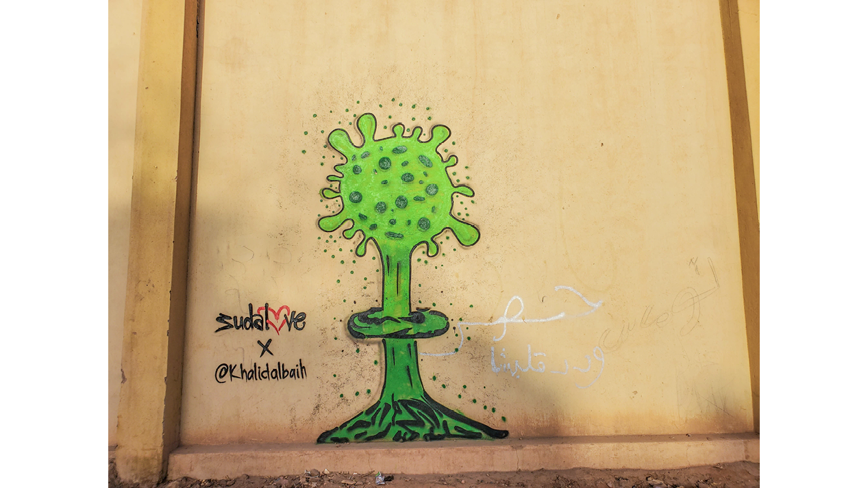 An image painted in spray paint on a wall. A laboratory flask spews out a green spherical form with the virus’s crown-like protein spikes. Tiny green dots surround the flask.