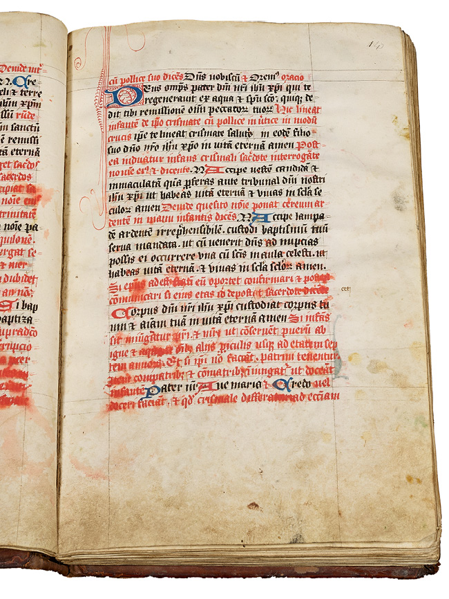 Right half of an opening, with a rubricated noted ritual made in England in the fifteenth century. It contains instructions for performing a Baptism. Holy water that has splashed on the book has caused the red ink to run.