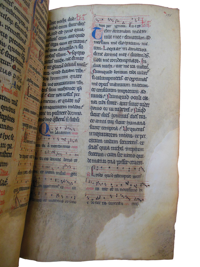 Right half of an opening of the Grand Obituary of Notre-Dame showing a noted Mass for the dead, where the bottom third of the page is browned and degraded, and the corners have been repaired. The repair is made more visible with backlighting.