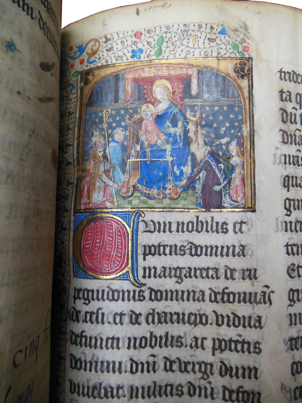 Detail from the Grand Obituary of Notre-Dame, from an added obituary for Lady Margaret of Roche-Guyon, made in Paris around 1472. It shows Christ holding scales as Margaret and a bishop fill the scales with gifts. The figure of Margaret has been heavily abraded.