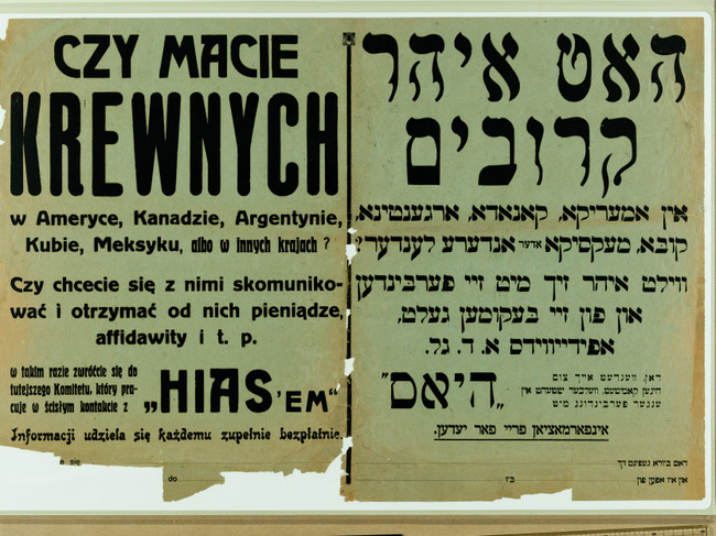 Poster advertising getting in touch with emigrated relatives printed with black ink on a roughly torn piece of green paper, with words written both in Polish and Hebrew.