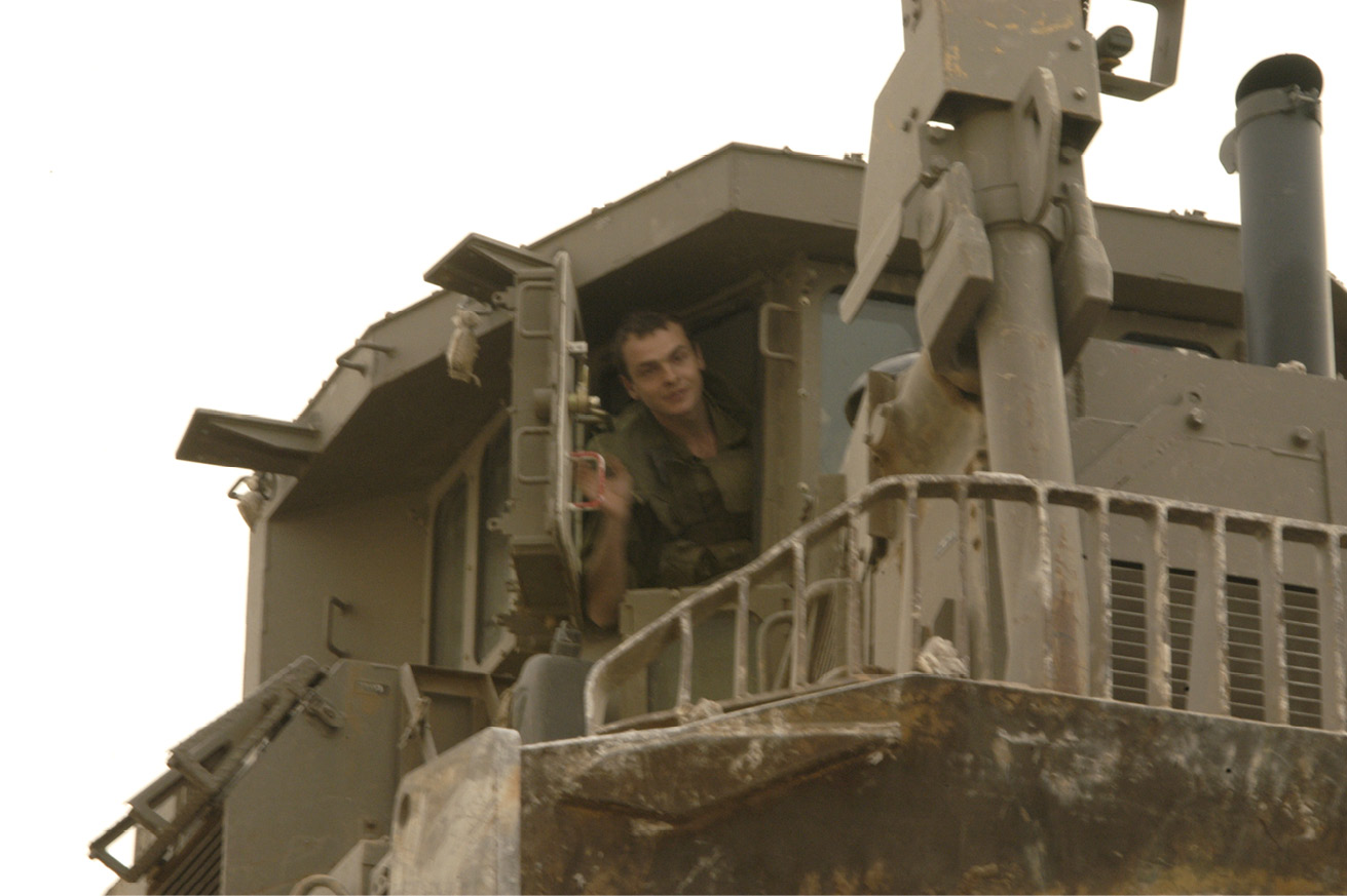 Close-up of an Israeli soldier opening a window from inside an armoured observation post.