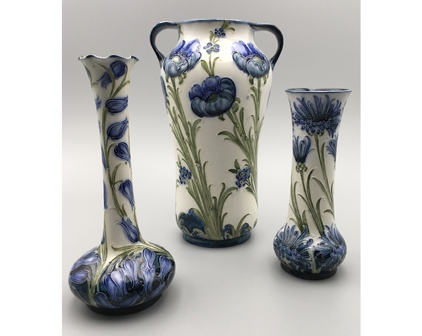 Harebells curl up the stem of a slender vase; blue poppies and forget-me-nots wind up and across a vase of swollen form; cornflowers decorate the belly of a vase, extending to the top in different stages of bloom.",,,