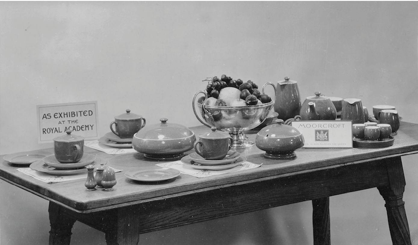 A photograph of a table displaying items in Powder Blue, including teaware, jugs, tureens, plates and cruets. A notice on the table reads: ‘As Exhibited at the Royal Academy’. ",,,