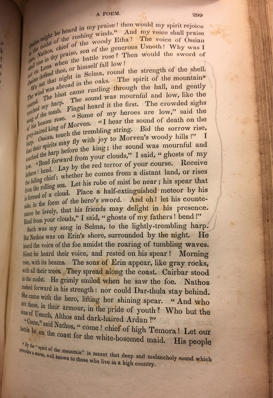An old printed book with mottled pages held open on page 299.