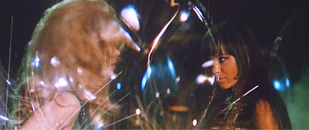 A confrontation between Barbarella and another character in the 1968 sci-fi film “”Barbarella””. The scene is visually striking, with reflections and distortions created by glass or crystal structures, lending a surreal, dreamlike quality.”,