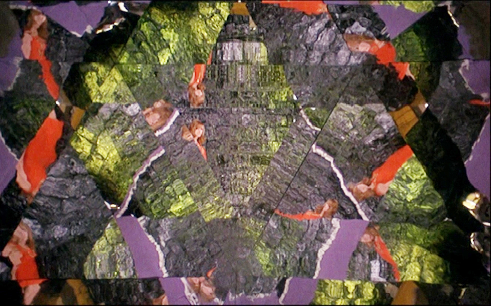 Another kaleidoscopic visual from “”La Prisonnière”” (1968), where reflections of the woman in red and distorted surroundings are multiplied in geometric patterns, creating an otherworldly and fragmented scene.”,
