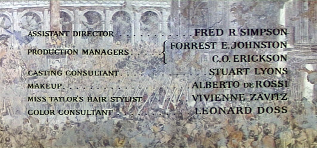 End credits of the film ‘Cleopatra’ showing key production roles such as assistant director Fred R. Simpson, production managers Forrest E. Johnston, C.O. Erickson, and color consultant Leonard Doss. The credits are displayed over a backdrop of an ancient Roman-style painting.”,