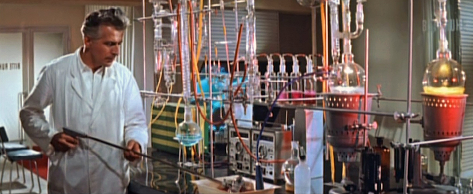 A scene from the 1960 East German-Polish science fiction film ‘The Silent Star’ (Der Schweigende Stern). The image shows a man in a cloak standing in a room with futuristic, Egyptian-themed decorations. The scene conveys an atmosphere of mystery and tension, characteristic of this film’s plot about an international space mission to Venus.”,