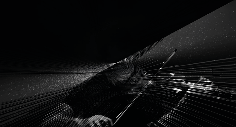 A black and white abstract image depicting a person playing the violin. The image features dynamic lines and light streaks radiating from the center, creating a sense of motion and intensity. The person’s face is obscured by diagonal shadows.