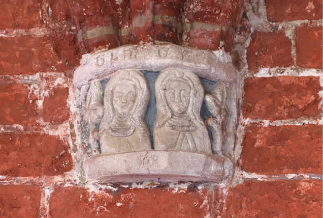 Sandstone console on a red brick wall in the cloisters of Kloster Ebstorf showing two carved busts of nuns in their habits with nuns’ crowns on top of their veils. Above them the initials GLM and GF are carved, below them a hexagram.