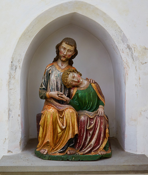 Painted wooden sculpture of Christ and John the Evangelist positioned in a wall niche. Their right hands are linked; the upright figure of Christ has his left hand lying on John’s left shoulder. John leans towards the left side of Christ. For an interpretation of the group see Chapter IV.3.