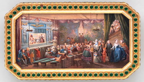 Boîte à priser de Jean-Etienne Blerzy avec miniature peinte de Louis-Nicolas Van Blarenberghe qui représente l’intérieur d’un théâtre pour marionnettes. Devant la scène il y a deux musiciens et un acteur costumé en Pierrot. Il y a un public assis devant le castelet sur des bancs et on distingue une porte d’entrée ainsi qu’un amphithéâtre. Sur la scène, deux personnages adultes dont une femme en robe. De la robe sortent trois enfants. Dans l’entrée, plusieurs personnages de haut rang et vêtus richement s’avancent vers l’ouvreuse. L’ensemble est très coloré et donne une impression de brouhaha.
