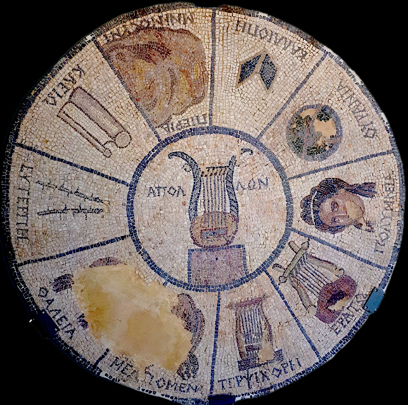 Ancient Greek mosaic representing the arts, featuring a central lyre surrounded by various artistic symbols and Greek inscriptions.