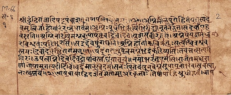 An ancient manuscript with Sanskrit text written in Devanagari script on aged, brownish paper. The text is carefully scribed, with some annotations in red ink, suggesting it might be a religious or scholarly work.